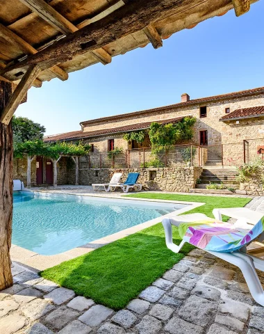 Casa rural Le Moulin de la Roche en Tiffauges, con su gran piscina y paredes de piedra vista, un lugar perfecto para unas vacaciones familiares cerca de Puy du Fou en Vendée